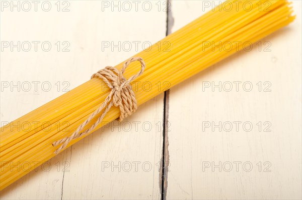 Italian pasta spaghetti tied with a rope on a rustic table