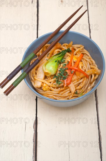 Hand pulled stretched Chinese ramen noodles on a bowl with chopstick