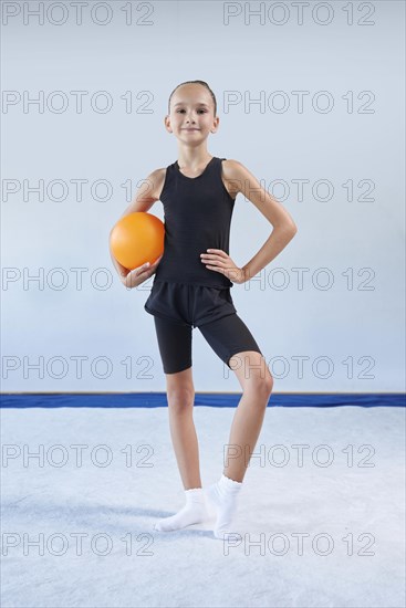 Image of a little girl with a ball in the gym. Gymnastics concept. Mixed media