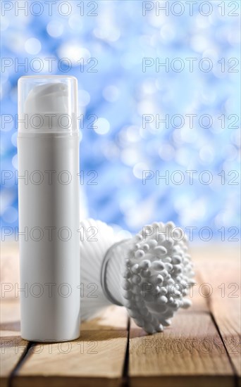 Cosmetic spray and cotton buds on a wooden table