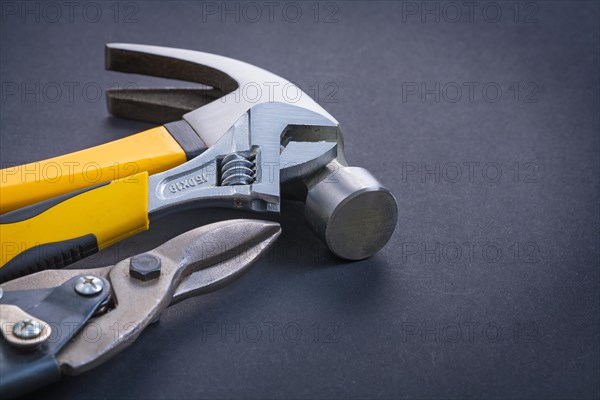 Adjustable spanner Claw hammer Steel cutter on black background
