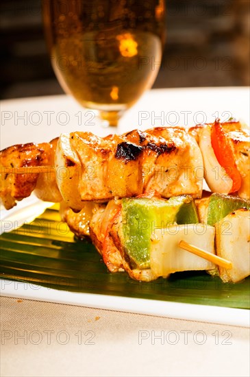 Fresh chicken and vegetables skewers on a palm leaf thai style