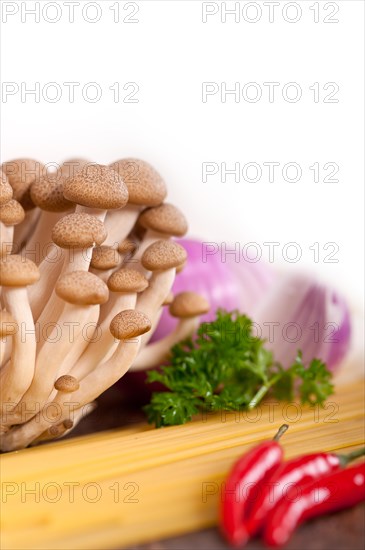 Italian pasta and mushroom sauce raw ingredients over rustic old wood