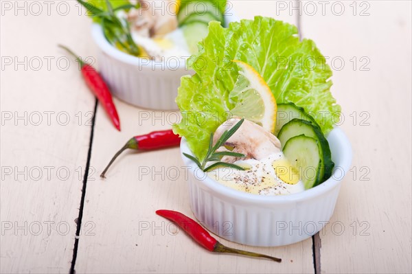 Fresh organic garlic cheese dip salad on a rustic table