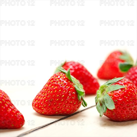 Fresh organic strawberry over white rustic wood table