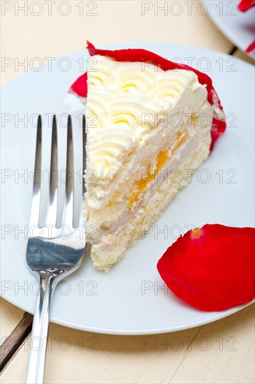 Whipped cream mango cake with red rose petals
