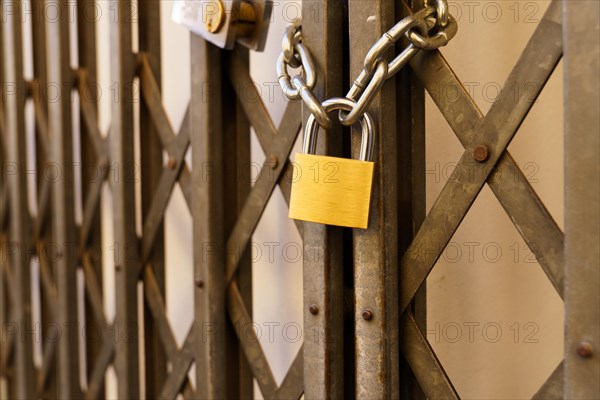 Metal door of a business closed with a padlock due to the crisis