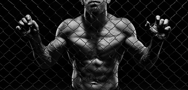 Black and white image of a man in a boxing cage. The concept of sports