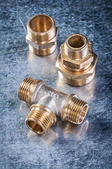 Brass equal tee hose nipples on metallic background plumbing concept
