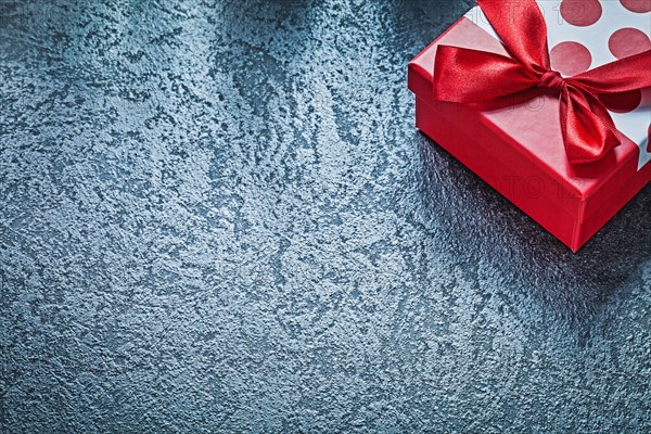 Wrapped present box with tied bow on black background celebrations concept