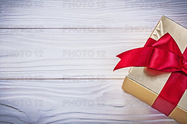 Birthday gift box with red satin tape on wooden board holidays concept