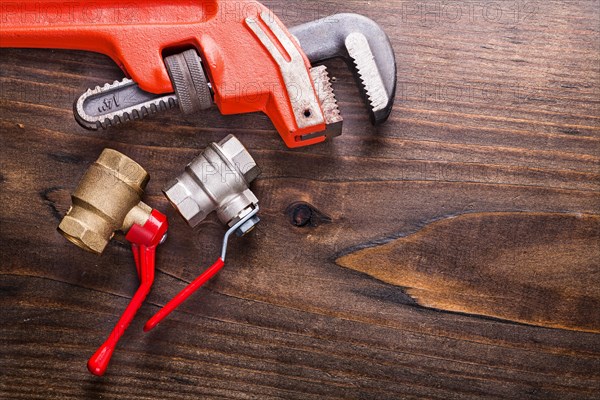 Monkey spanner and plumbing accessories on an old wooden board