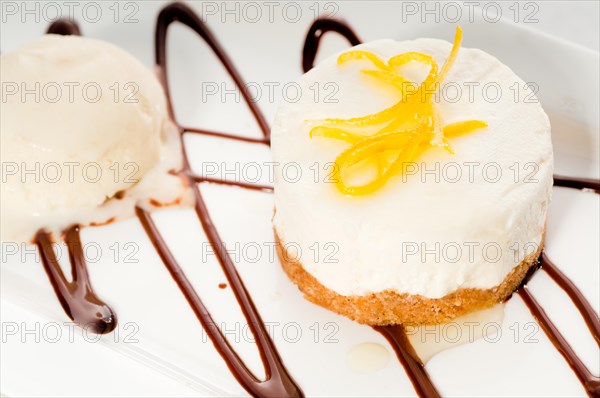 Very elegant lemon mousse dessert served whith lemon peel on top and vanilla ice cream on side