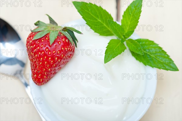 Organic Greek yogurt and strawberry over white rustic wood table