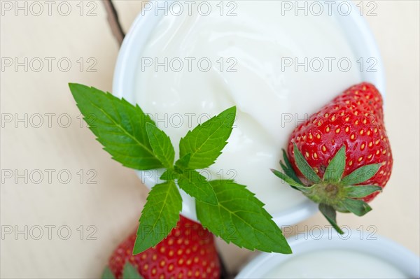 Organic Greek yogurt and strawberry over white rustic wood table