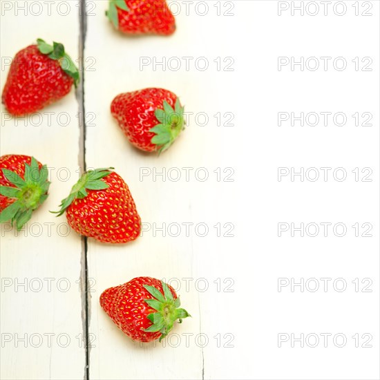 Fresh organic strawberry over white rustic wood table