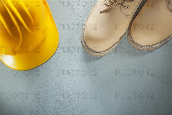 Hard hat waterproof safety boots on concrete background