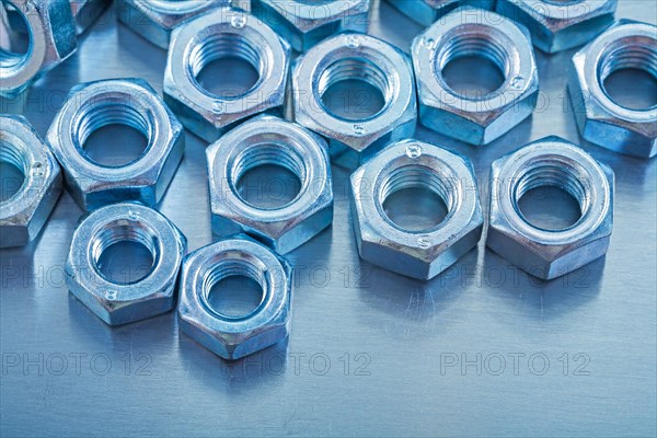 Close-up view of screw nuts on metallic background construction concept