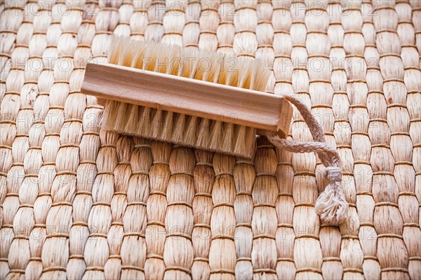 Single wooden scrubbing brush on wicker mat Healthcare concept