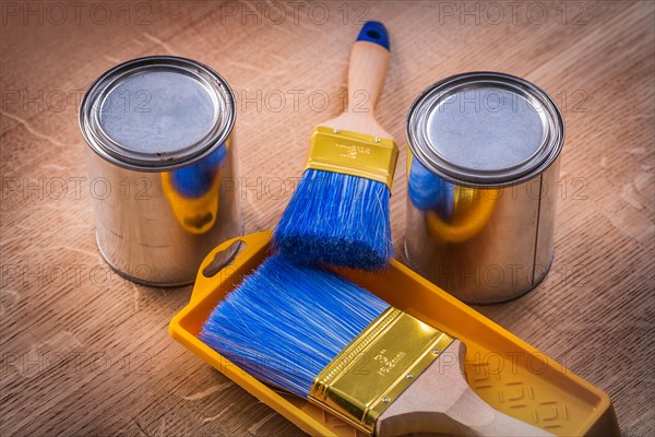 Two paint cans Brush tray on wooden board Construction concept