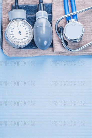 Organised copyspace stethoscope with blood pressure monitor on blue background medical concept