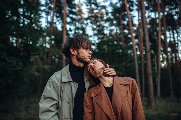 Romantic couple of lovers on a date in the park in cold weather. Fashionable couple in coat