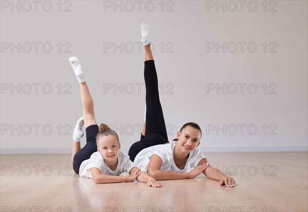 Beautiful female teacher poses with a little girl in a gymnastics class. The concept of education