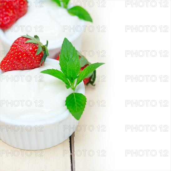 Organic Greek yogurt and strawberry over white rustic wood table