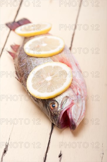 Fresh whole raw fish on a wooden table ready to cook