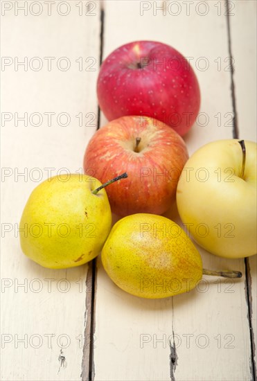 Fresh fruits apples and pears on a white wood table