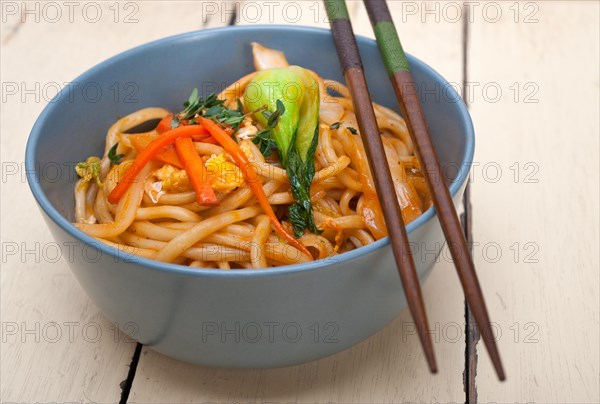 Hand pulled stretched Chinese ramen noodles on a bowl with chopstick