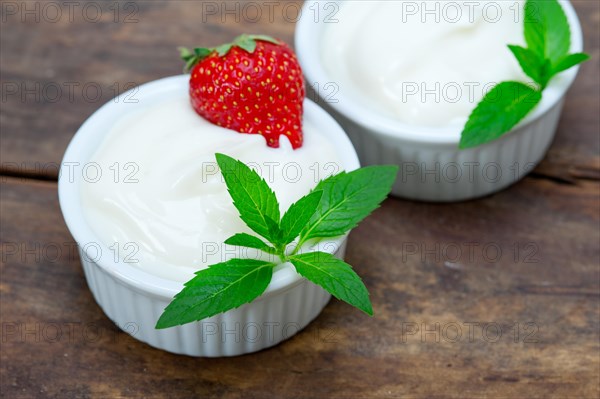 Organic Greek yogurt and strawberry on a rustic wood table