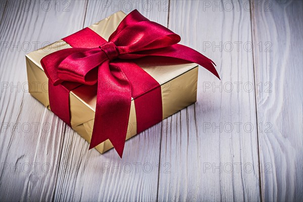 Golden present box on wooden board holidays concept