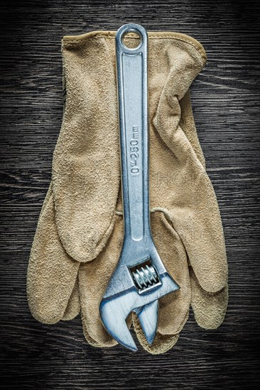 Adjustable spanner safety gloves on wooden board