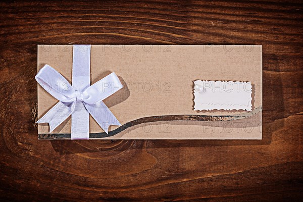 Light brown wedding invitation envelope on an old wooden board