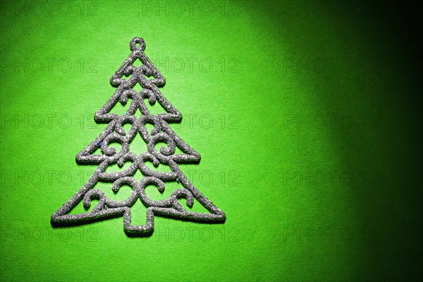 Christmas toy simbol of fir tree on green background horizontal version