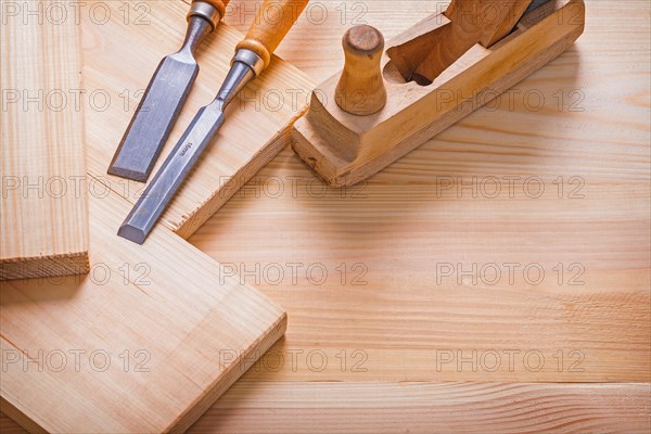 Old fashioned woodworkers plane carpentry chisel and wooden planks construction concept