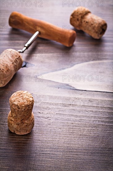 Champagne corks and corkscrew on vintage wooden board with copyspace alcohol concept