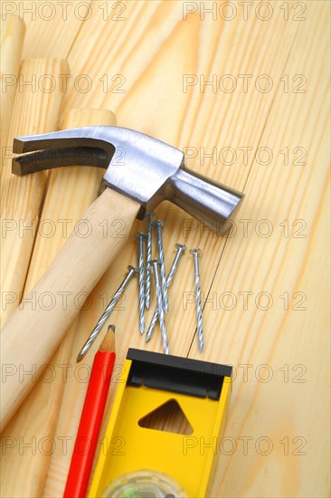 Claw hammer with nails and pencil on spirit level