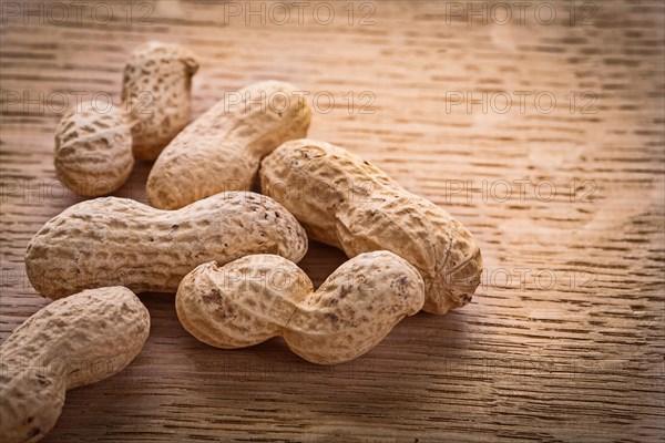 Small pile of peanuts on vintage wooden board Food and drink concept