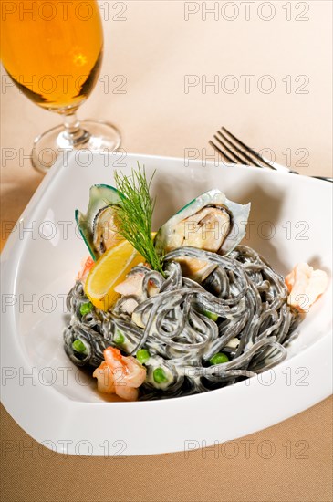 Fresh seafood black squid ink coulored spaghetti pasta tipycal italian food