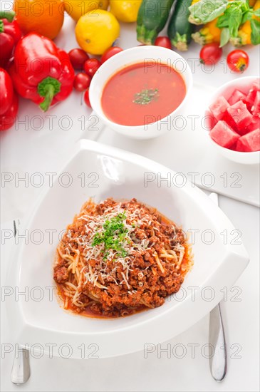 Italian classic spaghetti with bolognese sauce and fresh vegetables on background