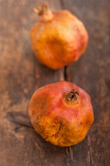 Dry and old pomegranates over rustic wood table
