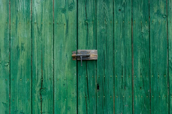 Old wooden door with aged metal door handle. Architectural textured background