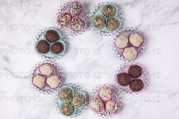 Light and dark rum balls arranged in a circle on glass plates