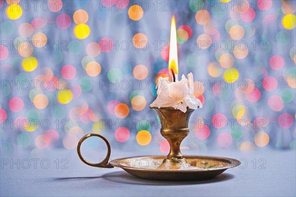 Gloving candle in vintage candlestick on background of bokeh