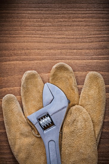 Adjustable key leather protective gloves on wood board construction concept