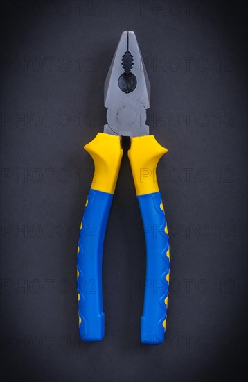 Aerial tongs with blue handles on a black background