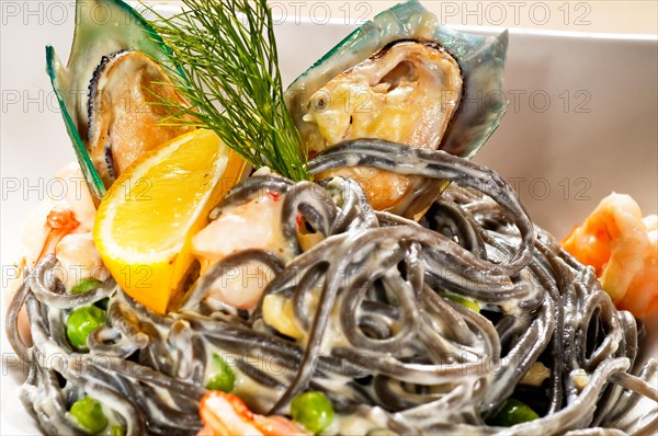 Fresh seafood black squid ink coulored spaghetti pasta tipycal italian food