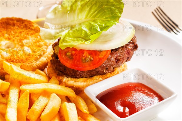 Fresh classic american hamburger sandwich with french fries and ketchup sauce on side